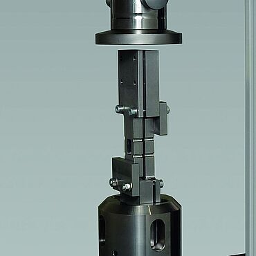 在两个压板之间使用带防压曲支架的试验工装进行符合ASTM D6484标准的开孔试样压缩试验（端面载荷）